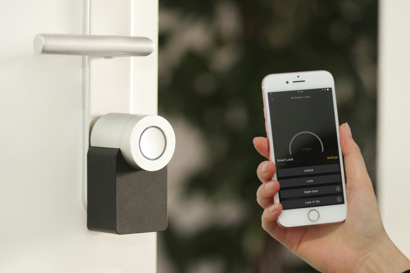 Smart lock beside a door handle with a phone showing lock controls